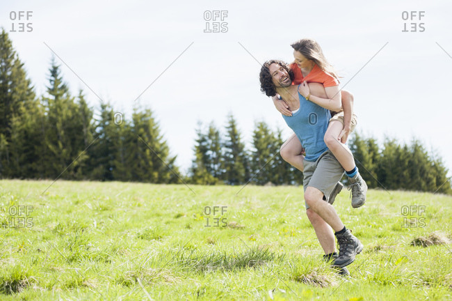 Man carrying his wife on back in summer- Wallberg- Bavaria- Germany