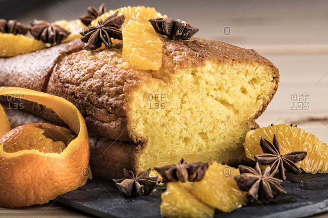 Delicious soft orange cake served with orange slices on slate board