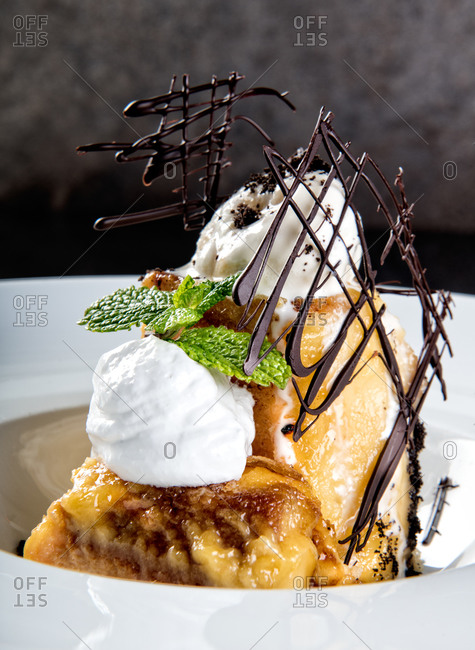 Exquisitely served portion of sweet sponge cake with vanilla ice cream and chocolate decorative lattice