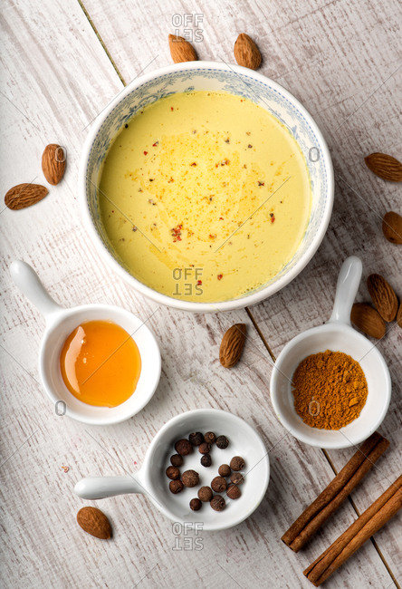Top view of delectable banana milk soup placed on table with almond and cinnamon