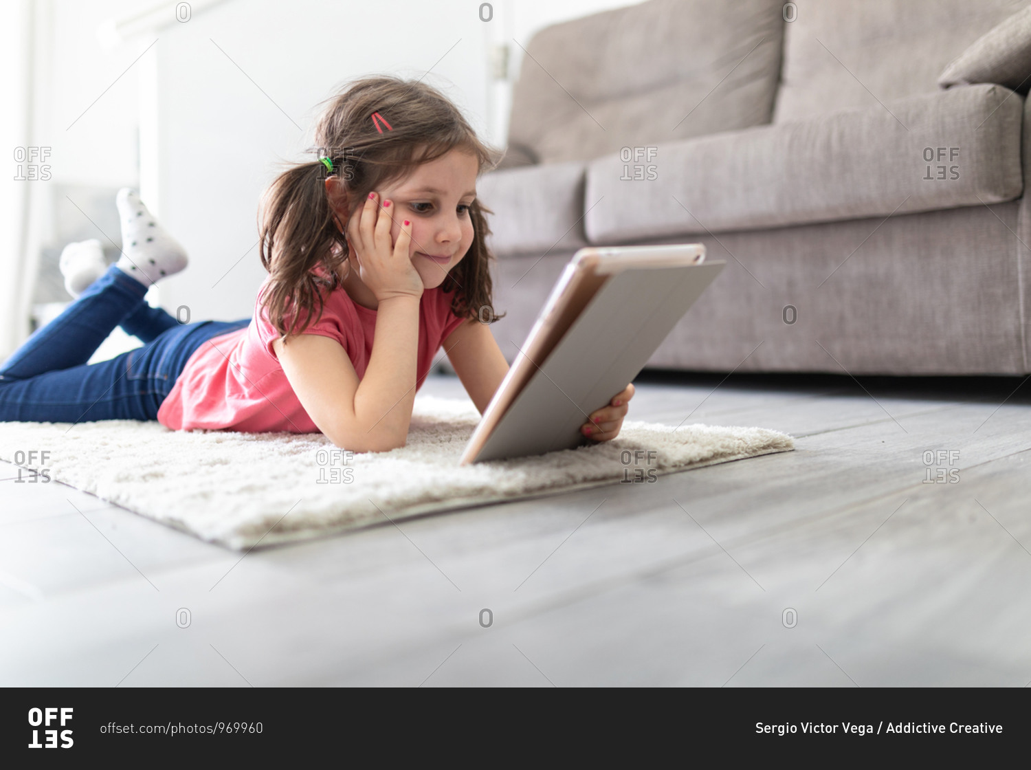 cute little girl holding and using digital tablet touching screen