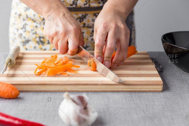 Woman cutting carrots on cutting board