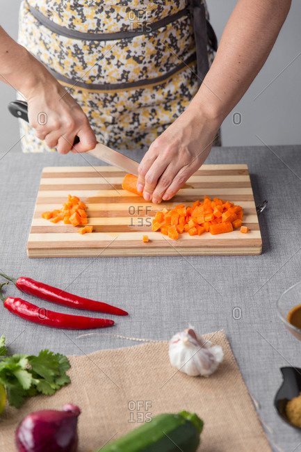 Woman cutting carrots on cutting board
