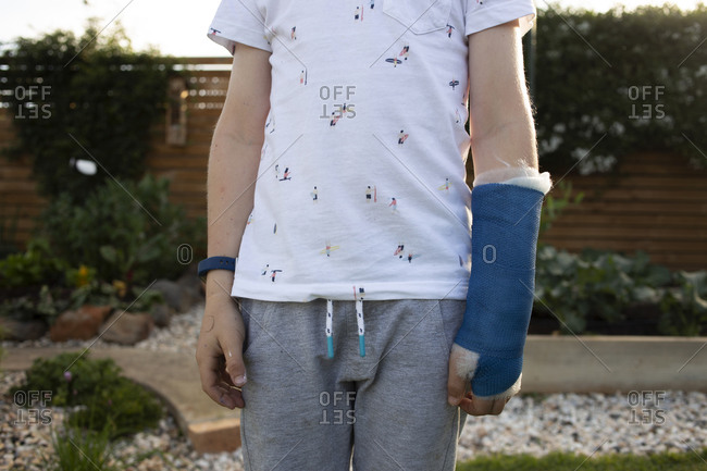 Mid-section of a young boy wearing a blue cast on his arm