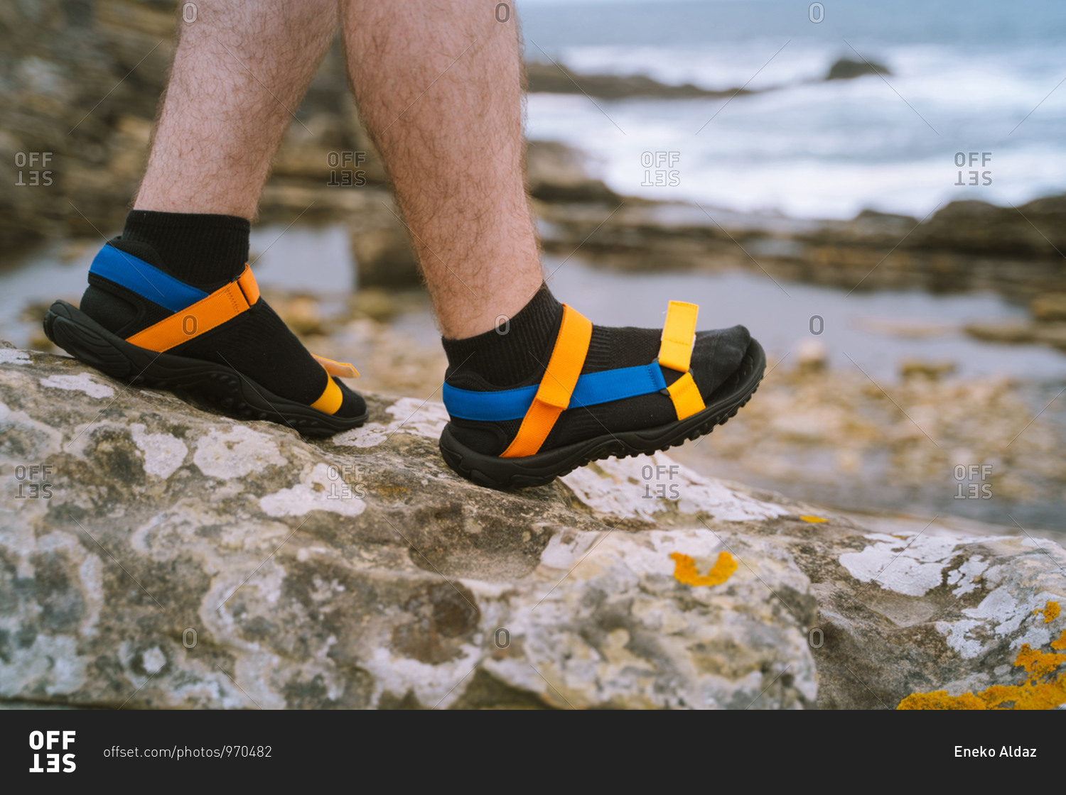 Hairy legs wearing colorful sandals with black socks