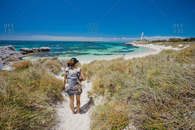 Mother with son in baby carrier on beach, Western Australia, Australia