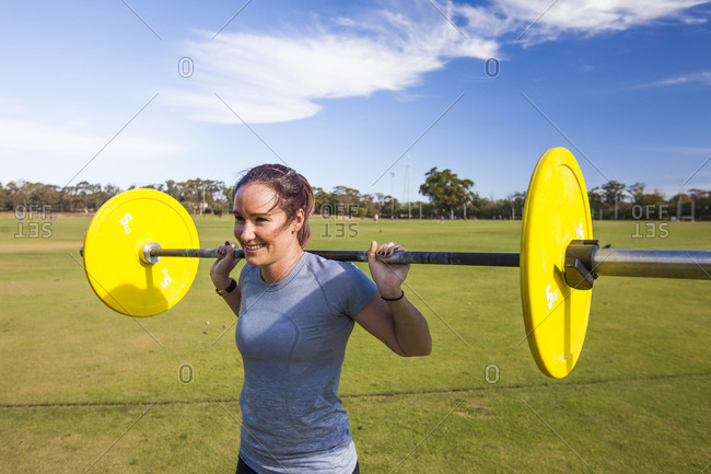 Woman weightlifting outdoors to gain strength