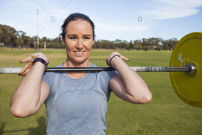 Woman weightlifting outdoors to gain strength