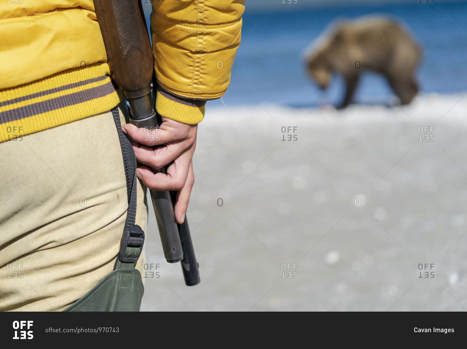 Park ranger with shotgun watching brown bear, Kurile Lake, Kamchatka Peninsula, Russia