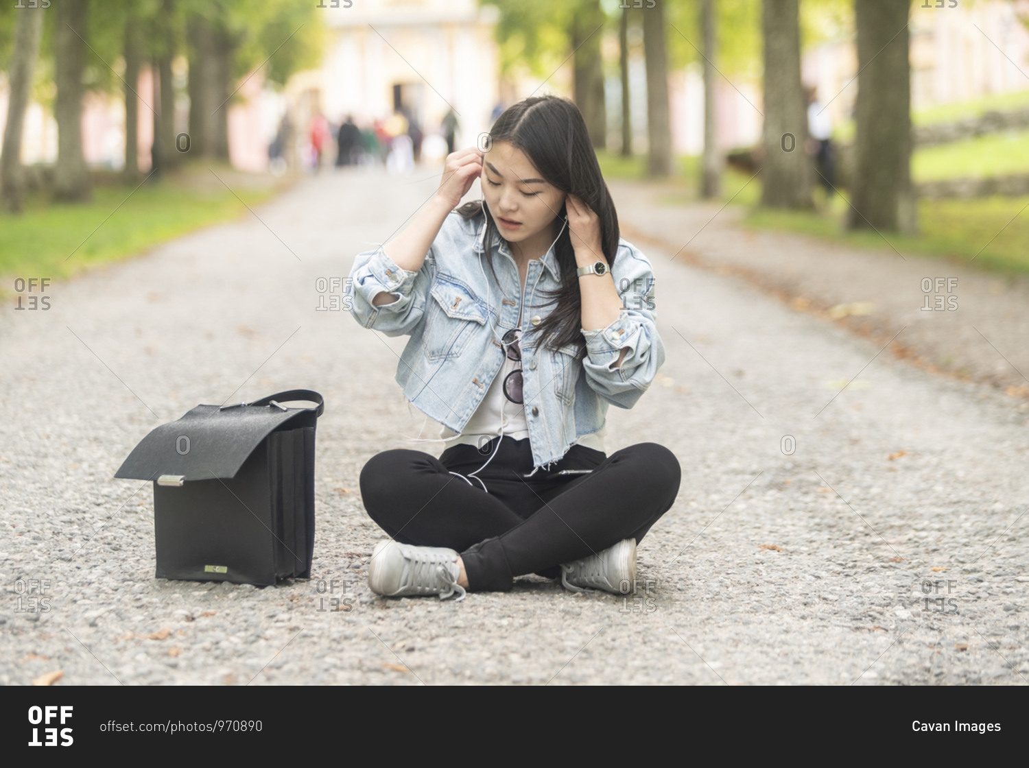 Asian female sitting on the ground and listening to music