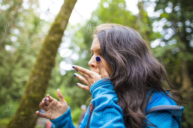Girl eating berries in forest alone