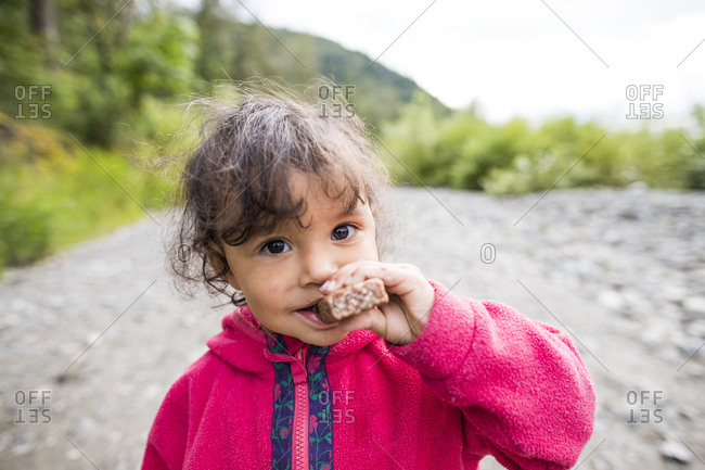 Girl eating chocolate bar while hiking