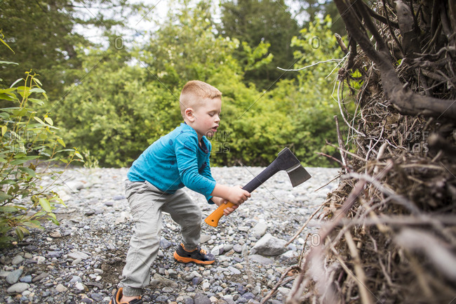 Boy using axe to chop wood