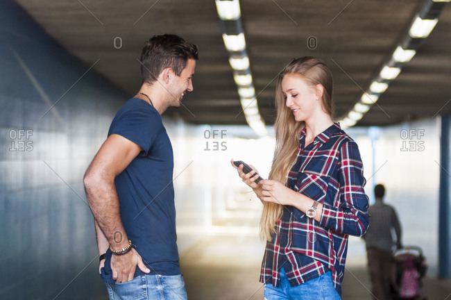 Young man and young woman standing together in an underpass