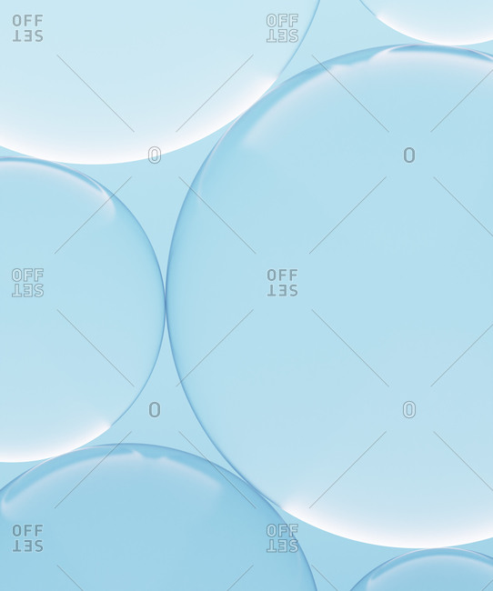 Three dimensional render of transparent glass spheres against blue background