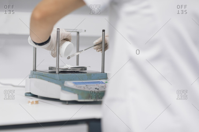 Female doctor weighing sample at laboratory