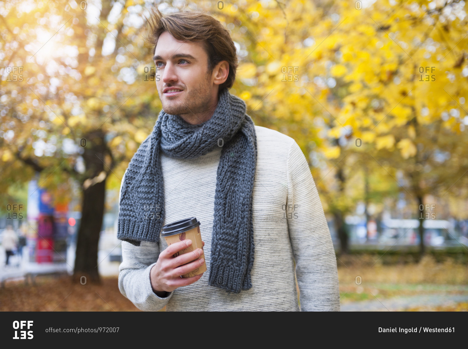 Portrait of young man with coffee to go in autumn