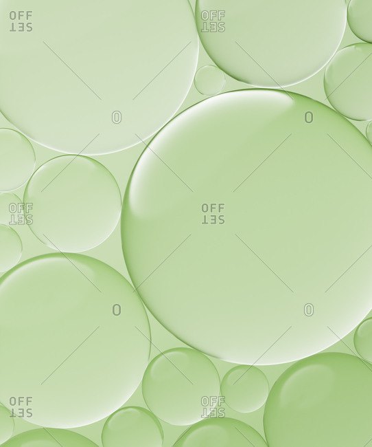 Three dimensional render of transparent glass spheres against green background