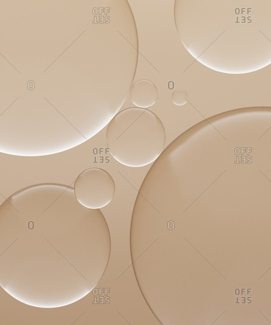 Three dimensional render of transparent glass spheres against light brown background