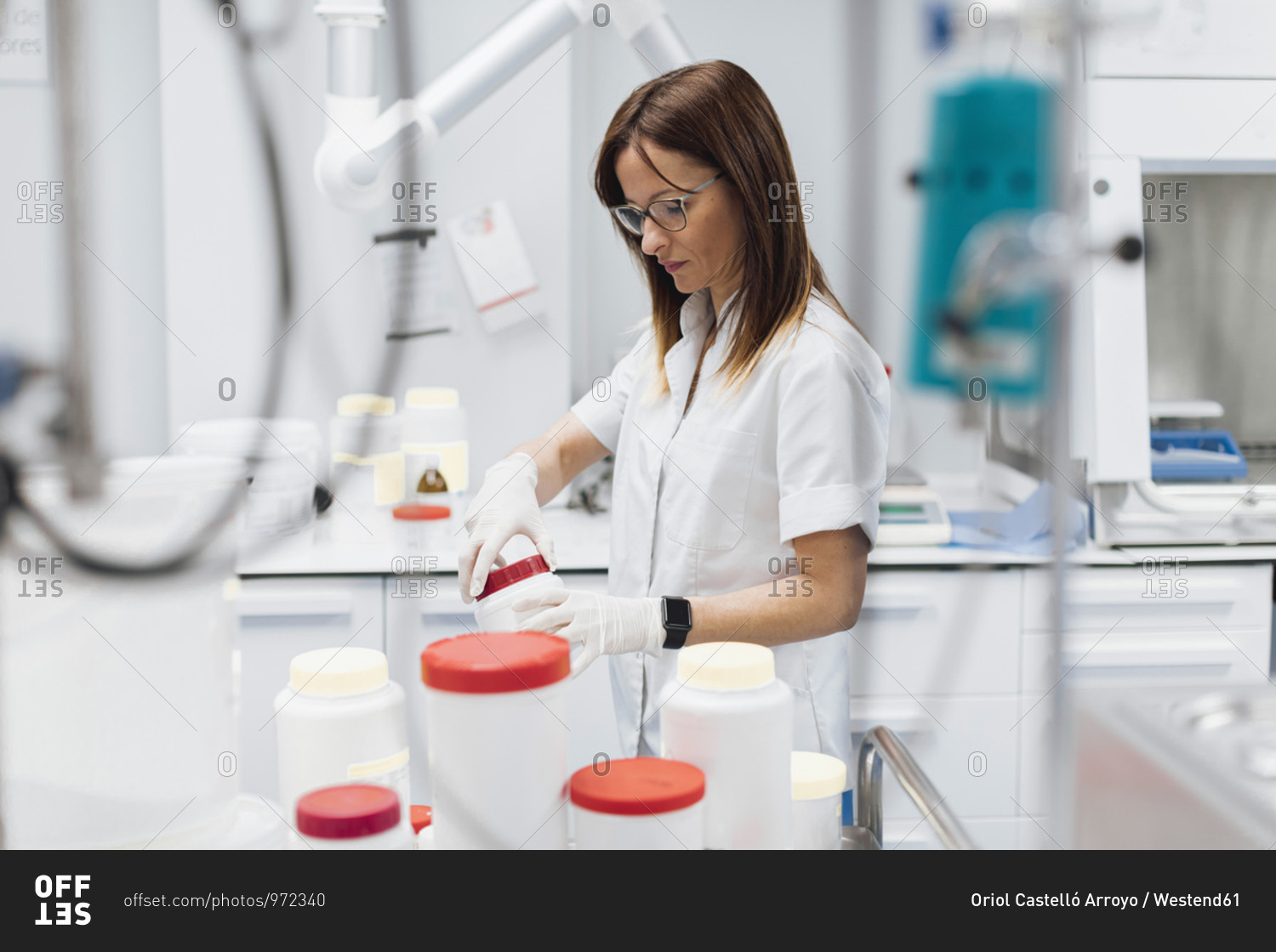 Confident female doctor opening jar while standing at laboratory