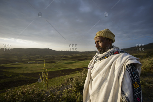 July 14, 2014: Ethiopian farmer watching his cattle at sunset, Debre Berhan, Ethiopia