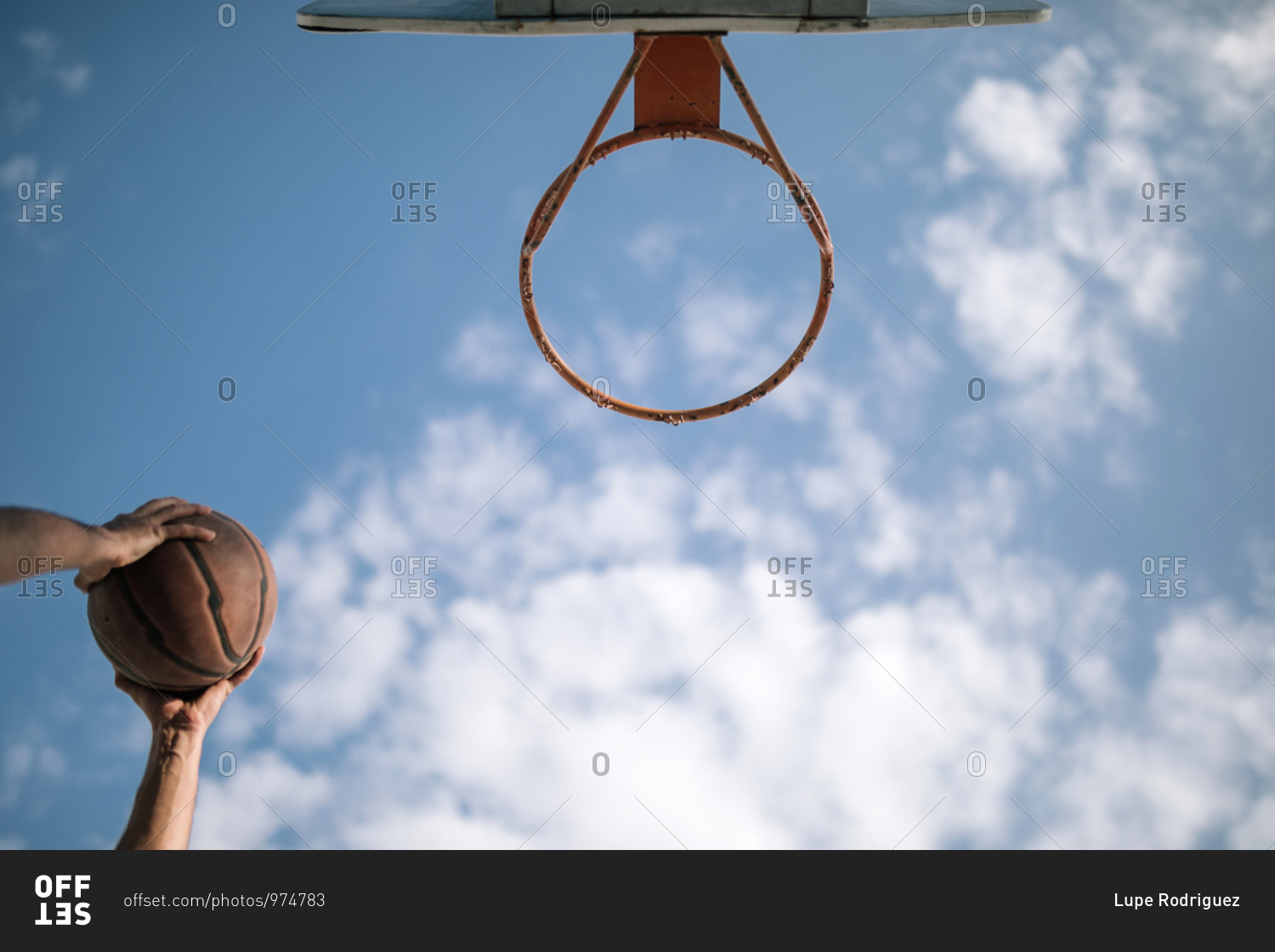 Teen boy putting basket into hoop on a basketball court