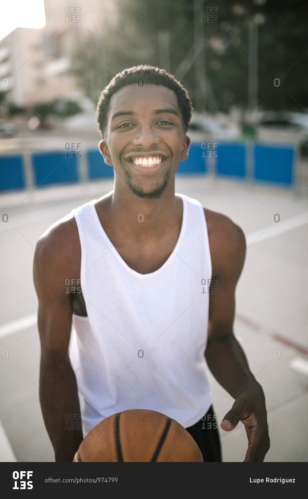 a-young-black-teenager-smiling-on-a-basketball-court-stock-photo-offset