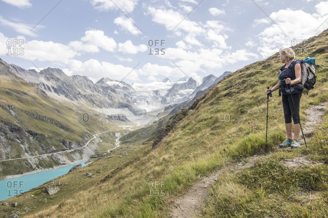 Senior hiker near lake in Swiss Alps Haute Route Traverse Valais Canton, Switzerland