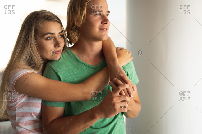 Caucasian couple standing, embracing and looking away. Social distancing and self isolation in quarantine lockdown.