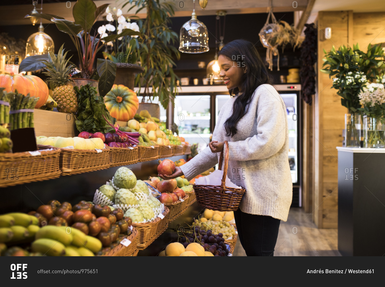 Young woman carrying wicker basket while buying fruits in grocery store