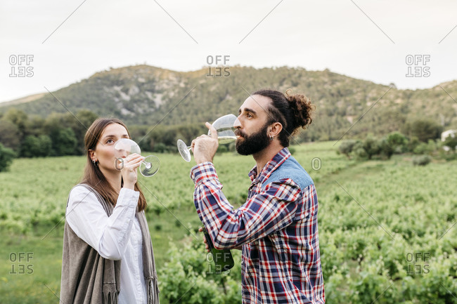 Couple tasting white wine at vineyard