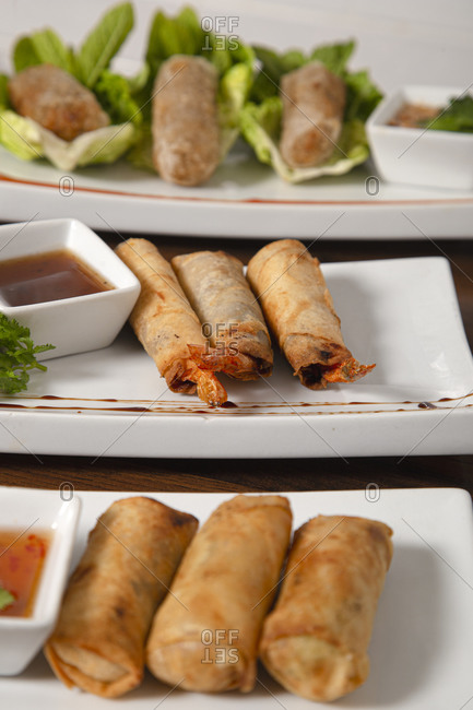 Traditional Asian crispy fried spring rolls with various fillings served with sauces and green salad