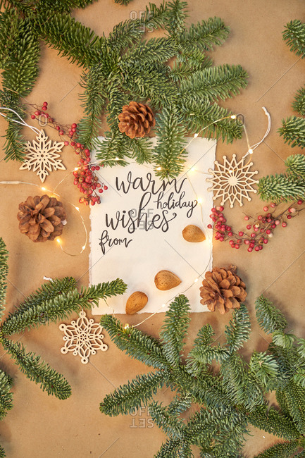 Christmas greeting written with a beautiful handmade letter with Christmas decorations and lights around.