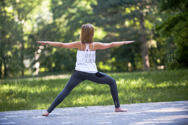 Caucasian woman pratices yoga outside