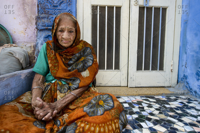 March 6, 2014: Old woman sitting on the floor outside her house, Jodhpur, India