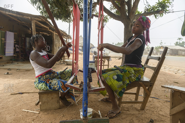 December 4, 2015: Girls and women work on their looms in a village in northern Benin, Africa