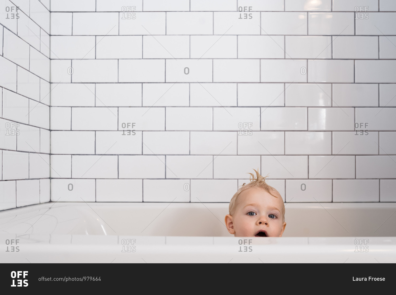 Little boy in bathtub with white subway tile surround