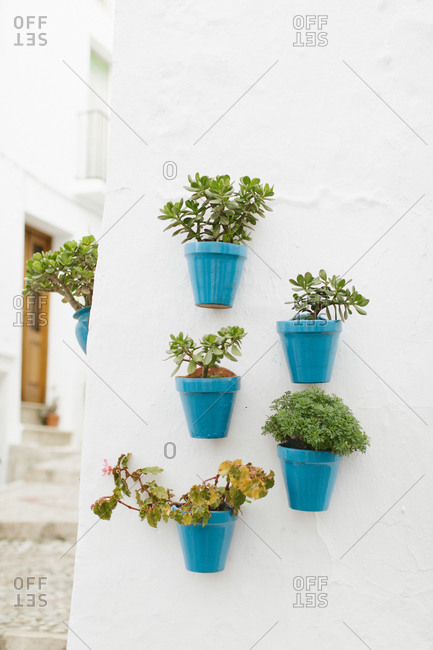 Typical south Spain wall of a patio with flowers in blue pots