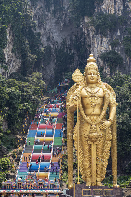 The tall golden Hindu statue of Murugan in front of the 272 steps to the Batu Caves with temples and shrines, near Kuala Lumpur, Malaysia, Southeast Asia, Asia