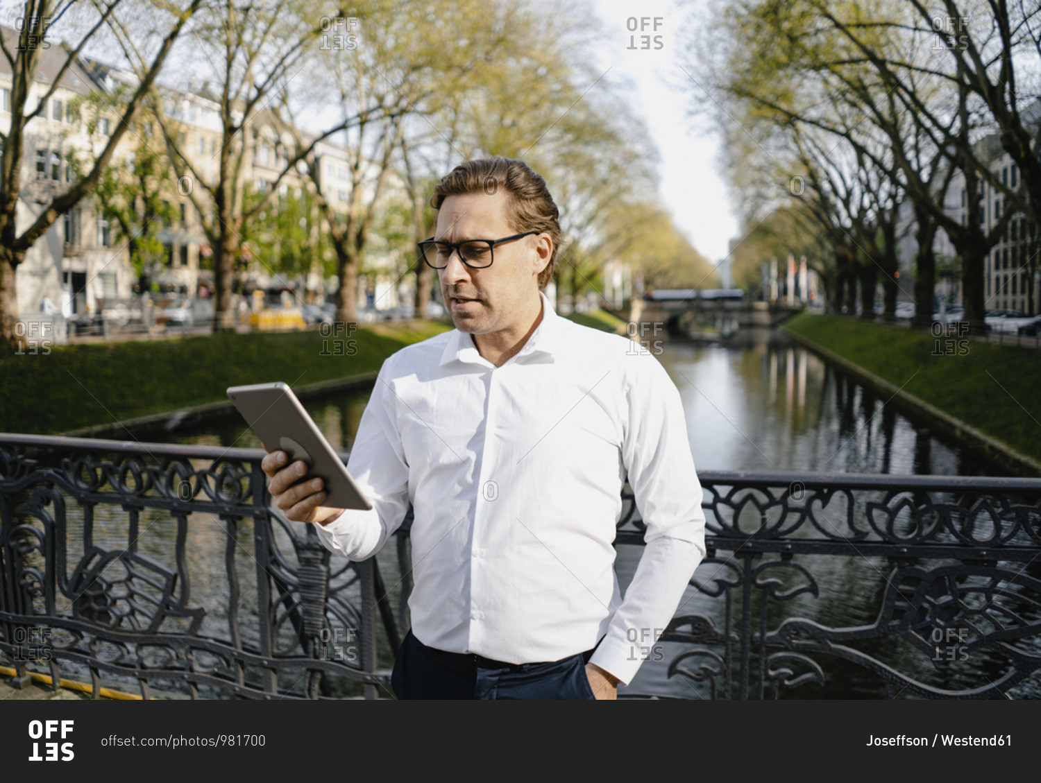 Businessman using tablet at a channel in the city