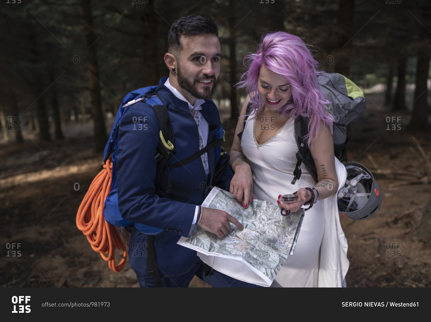 Bridal couple with hiking map in the woods