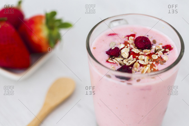 Glass of strawberry milkshake with cereals