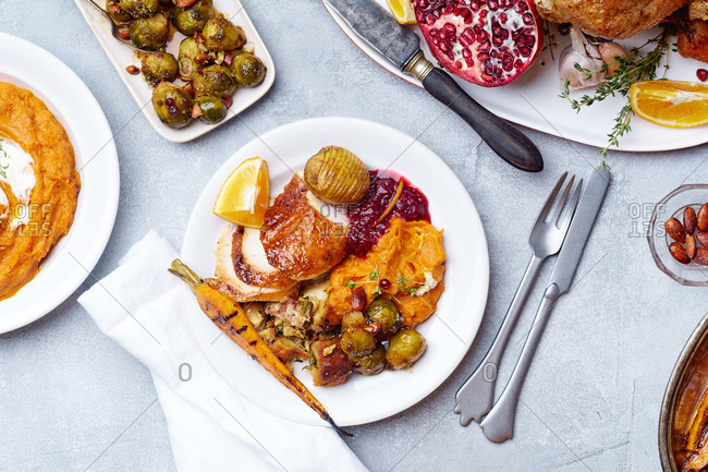 Top view of a plate with thanksgiving meal: roasted turkey, brussels sprouts and pumpkin puree.