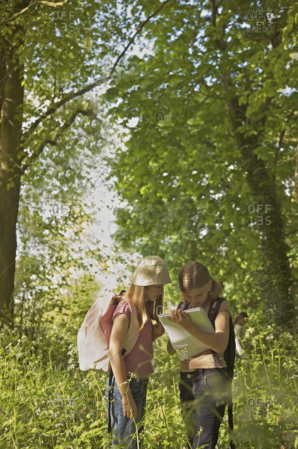 Girls with notebook on field trip in woods