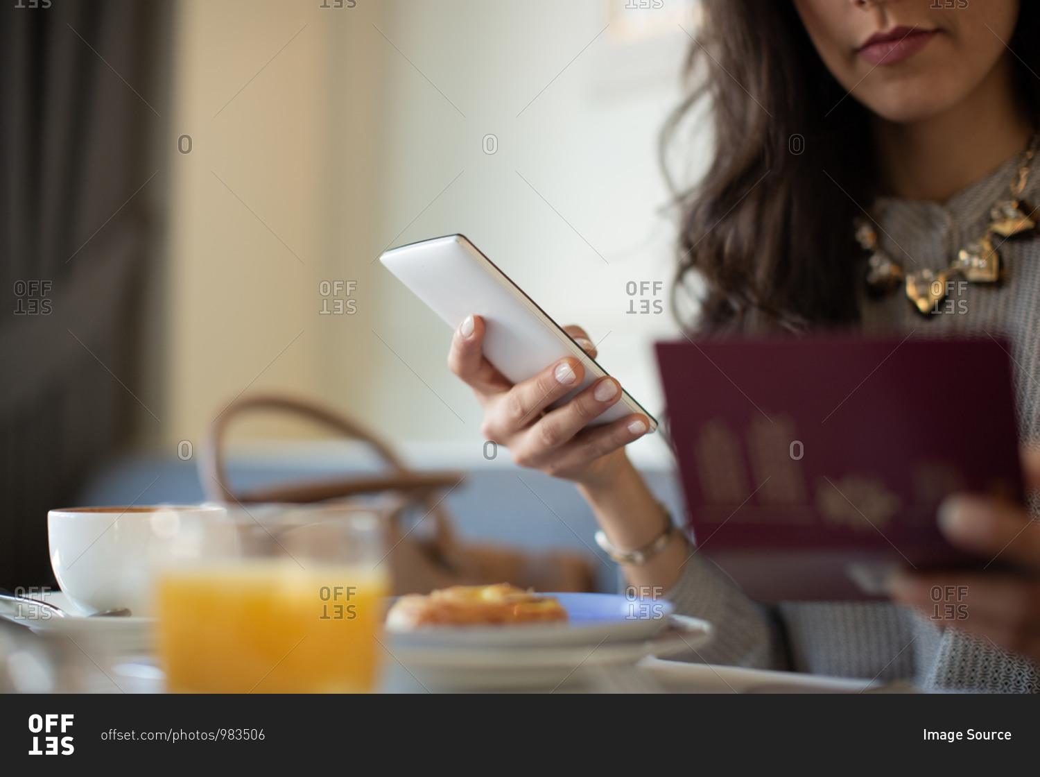 Cropped shot of young woman with digital tablet electronically checking in while having breakfast at boutique hotel in Italy