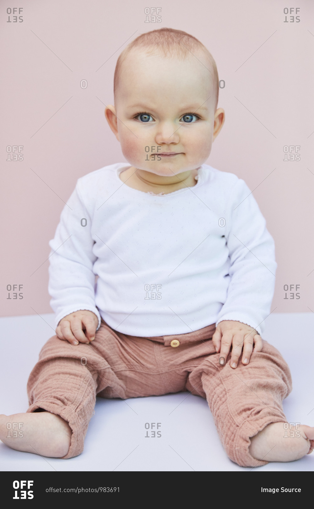 Portrait of baby girl on pink background.