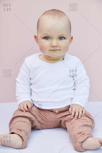 Portrait of baby girl on pink background.