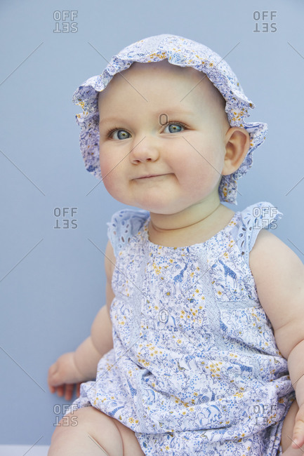 Portrait of baby girl on pale blue background.