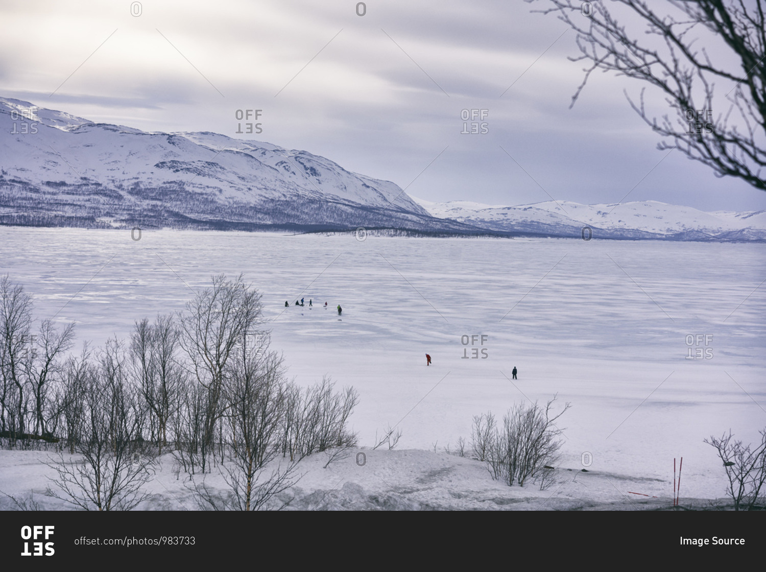 View across frozen lake with people in the distance, Vasterbottens Lan, Sweden.