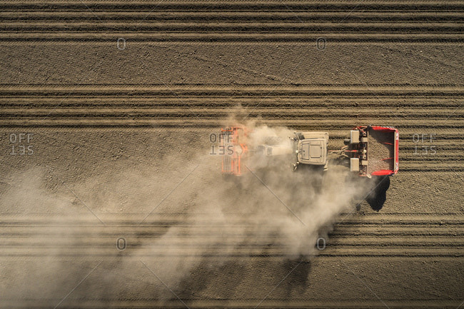 Aerial view of tractor blowing up dust on drought stricken potato field in Netherlands.